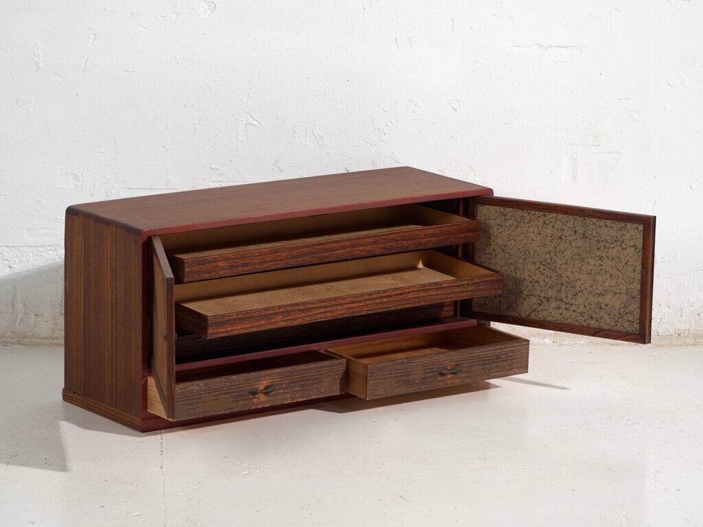 Small Japanese cabinet with sliding doors, Kabuki decoration, made of paulownia wood, early Showa period, circa 1926–1970.