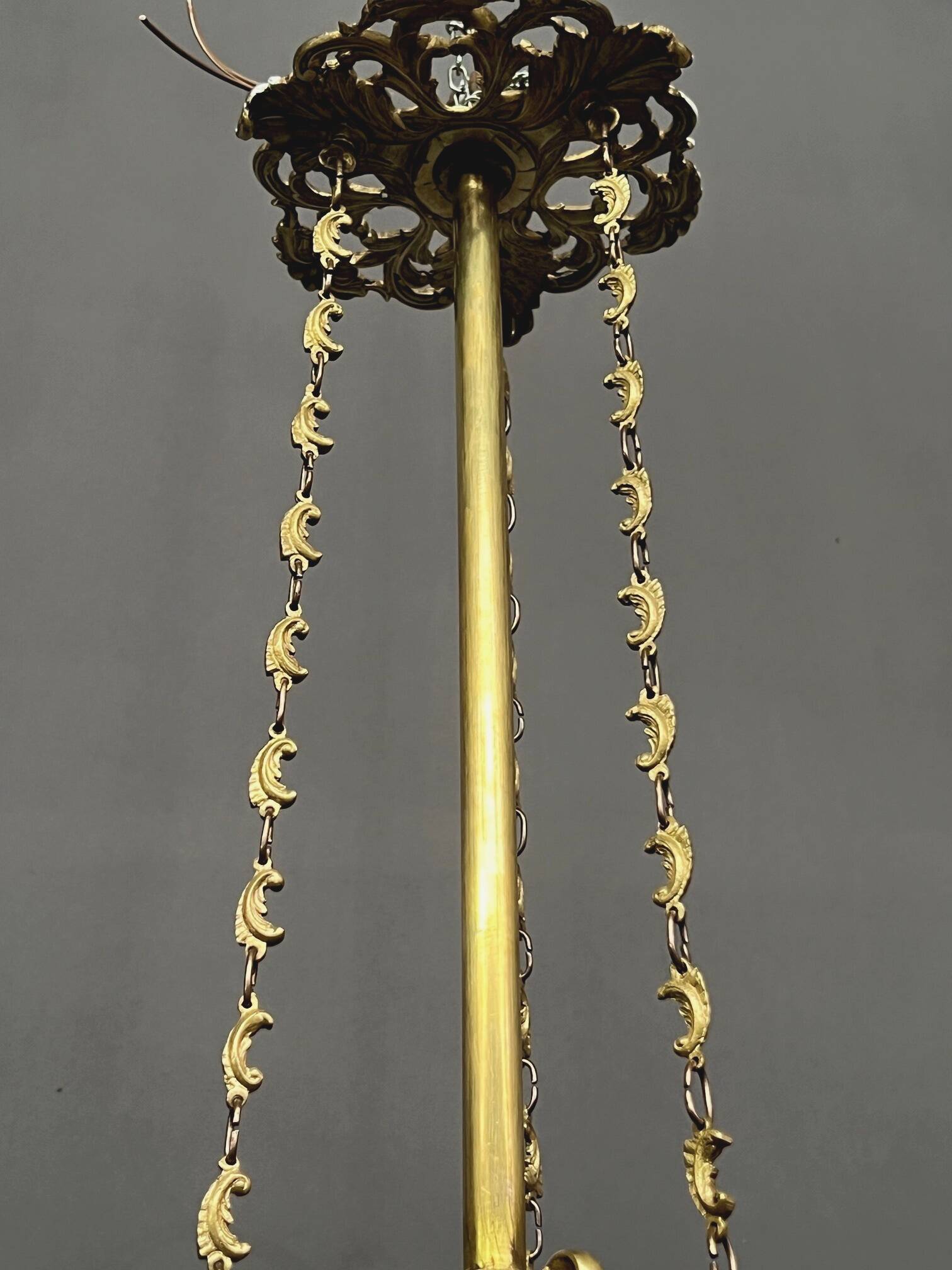 Antique chandelier in gilded bronze with crystal pendants.