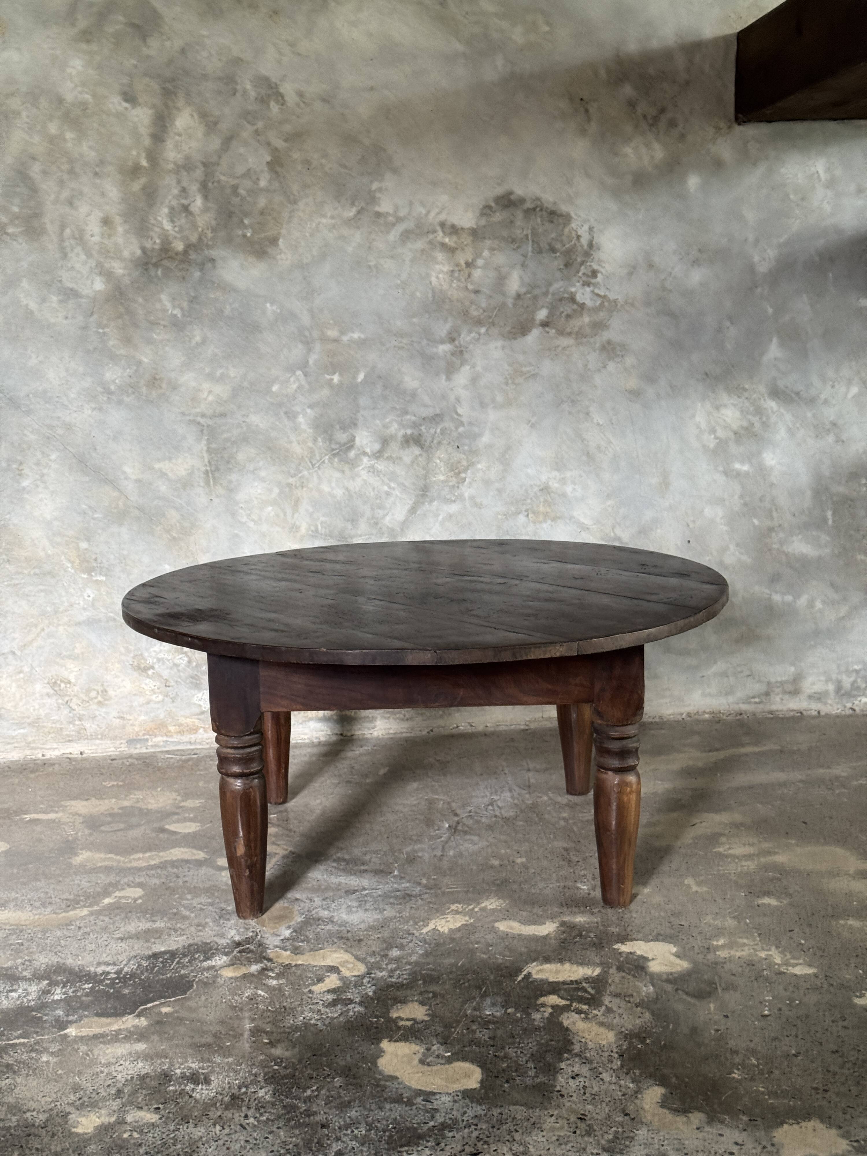 Coffee table, round antique Indonesian teak table with straight legs.