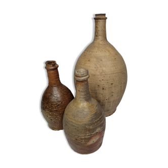 Set of three old enamelled terracotta bottles, 33 cm