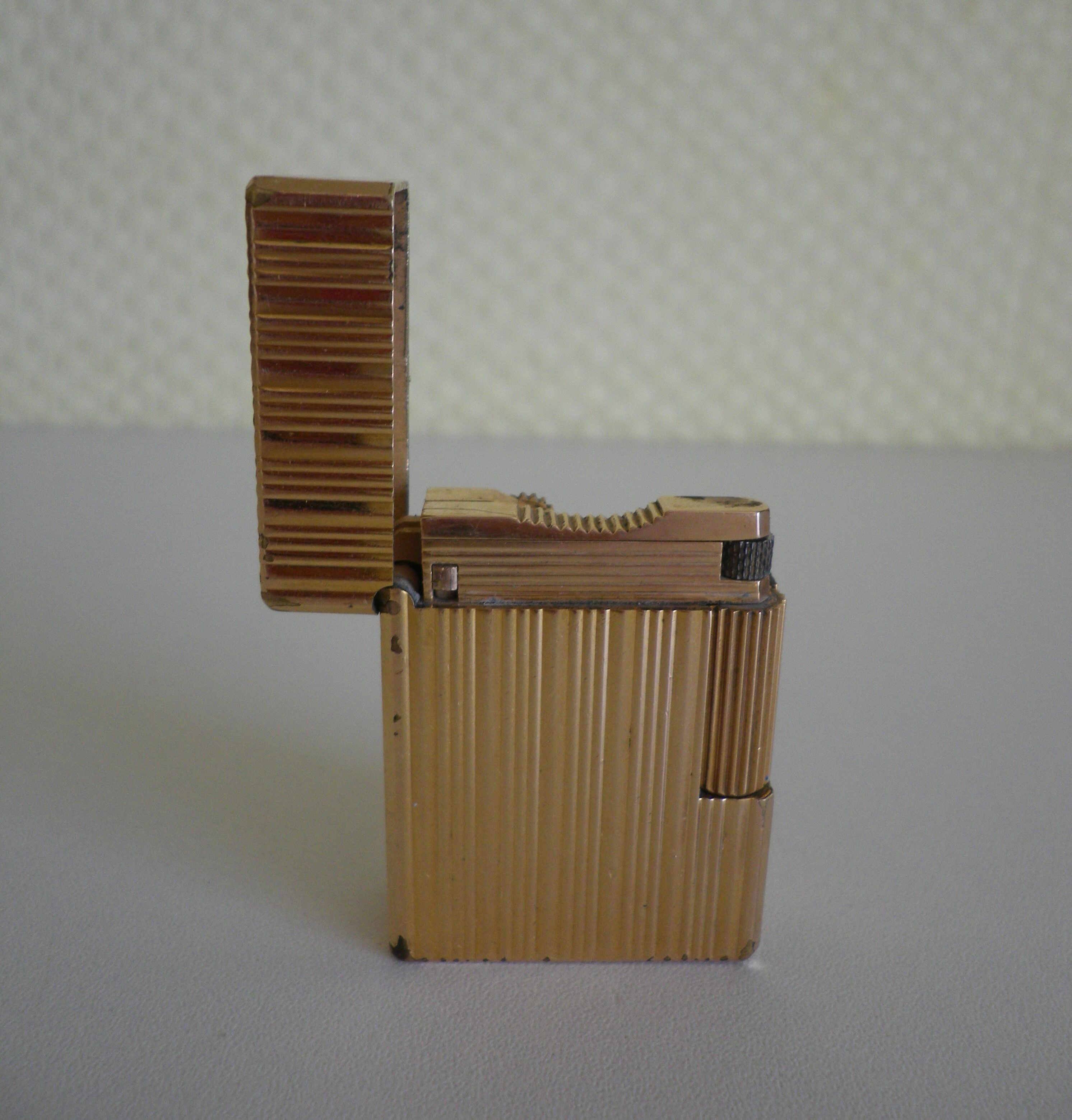 2 st dupont lighters, gold plated, punches, numbered, 1 striated pattern, 1 hammered pattern, 70s
