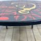 Vintage round coffee table in graphic red and yellow ceramic from the 1960s.