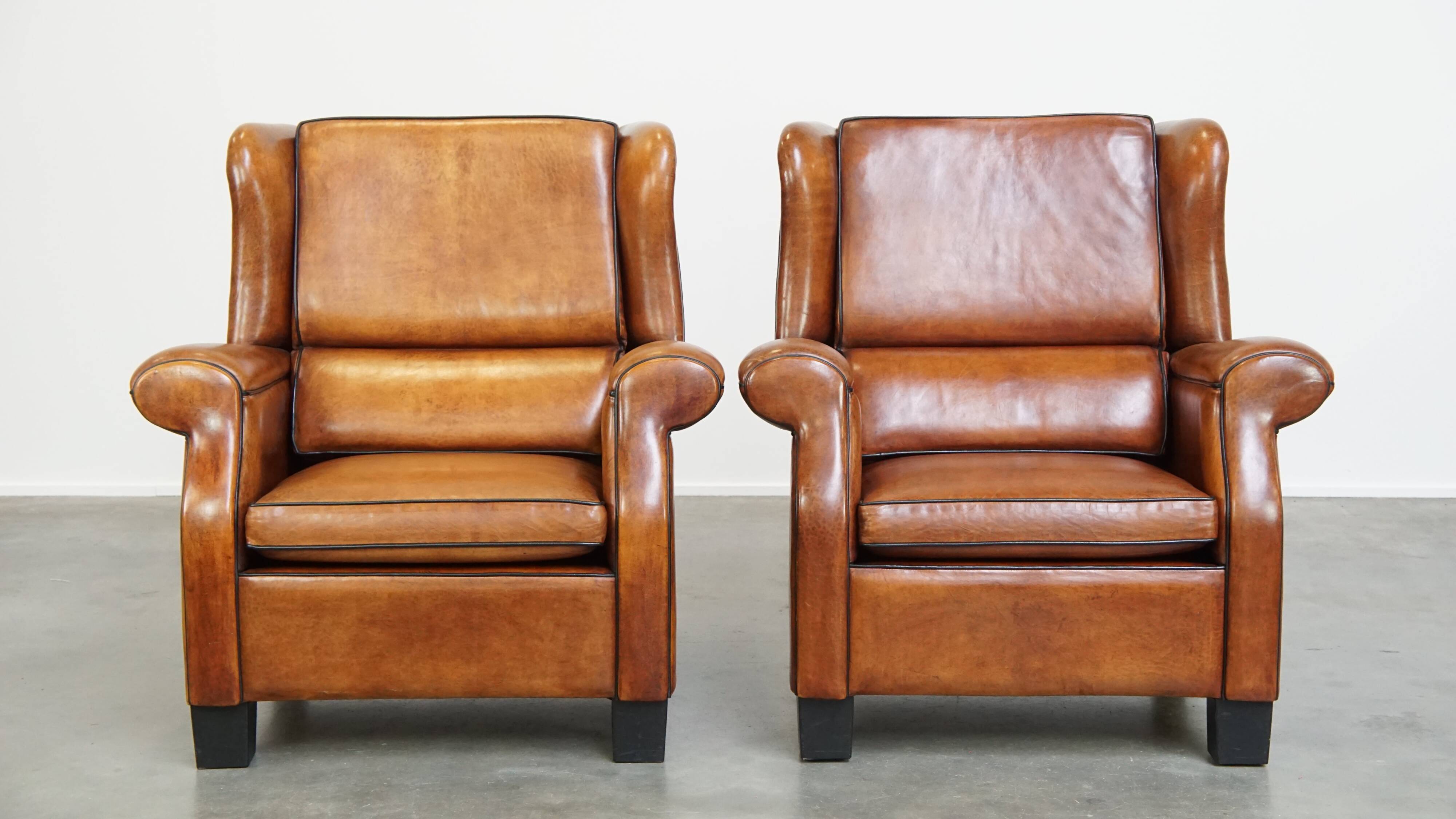 Set of 2 very comfortable large sheepskin armchairs elegantly finished with black piping