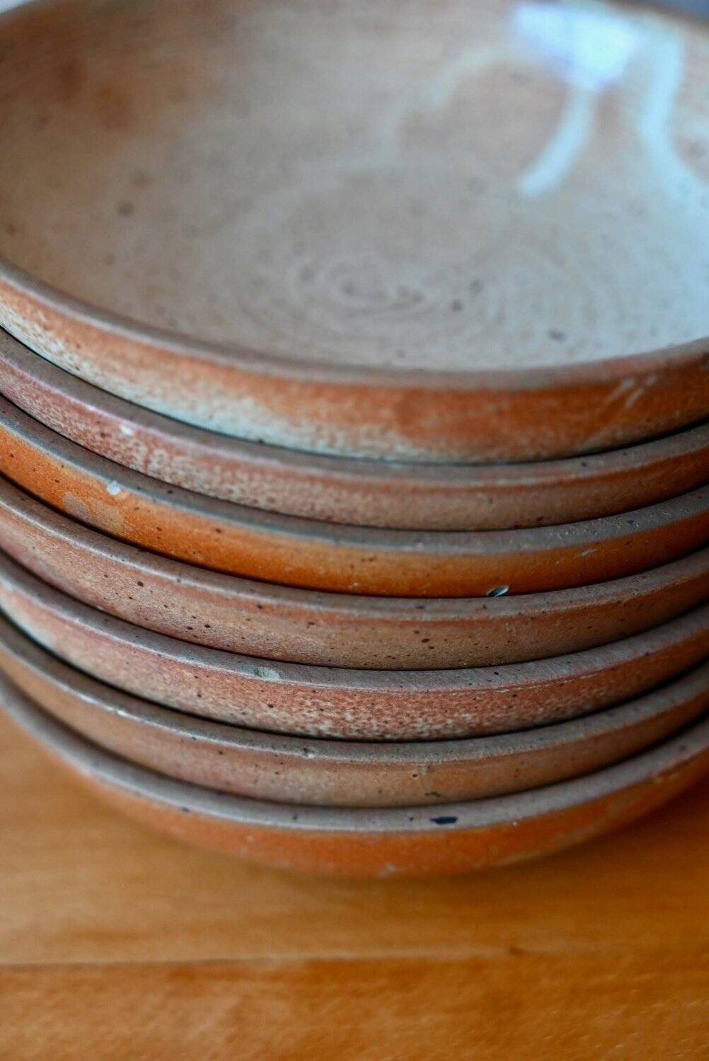 Set of 10 turned stoneware plates, pyritised and glazed, wabi-sabi brutalist.