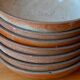 Set of 10 turned stoneware plates, pyritised and glazed, wabi-sabi brutalist.