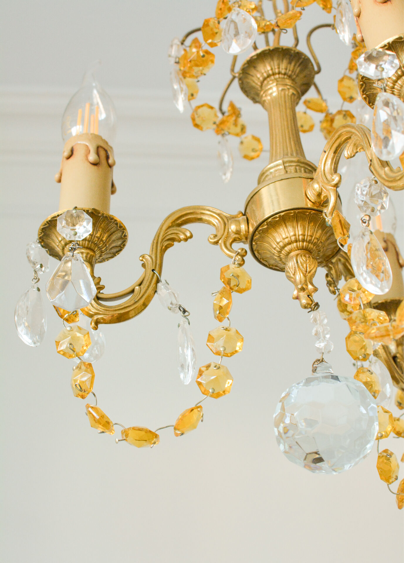 Small vintage brass chandelier with amber crystal pendants.