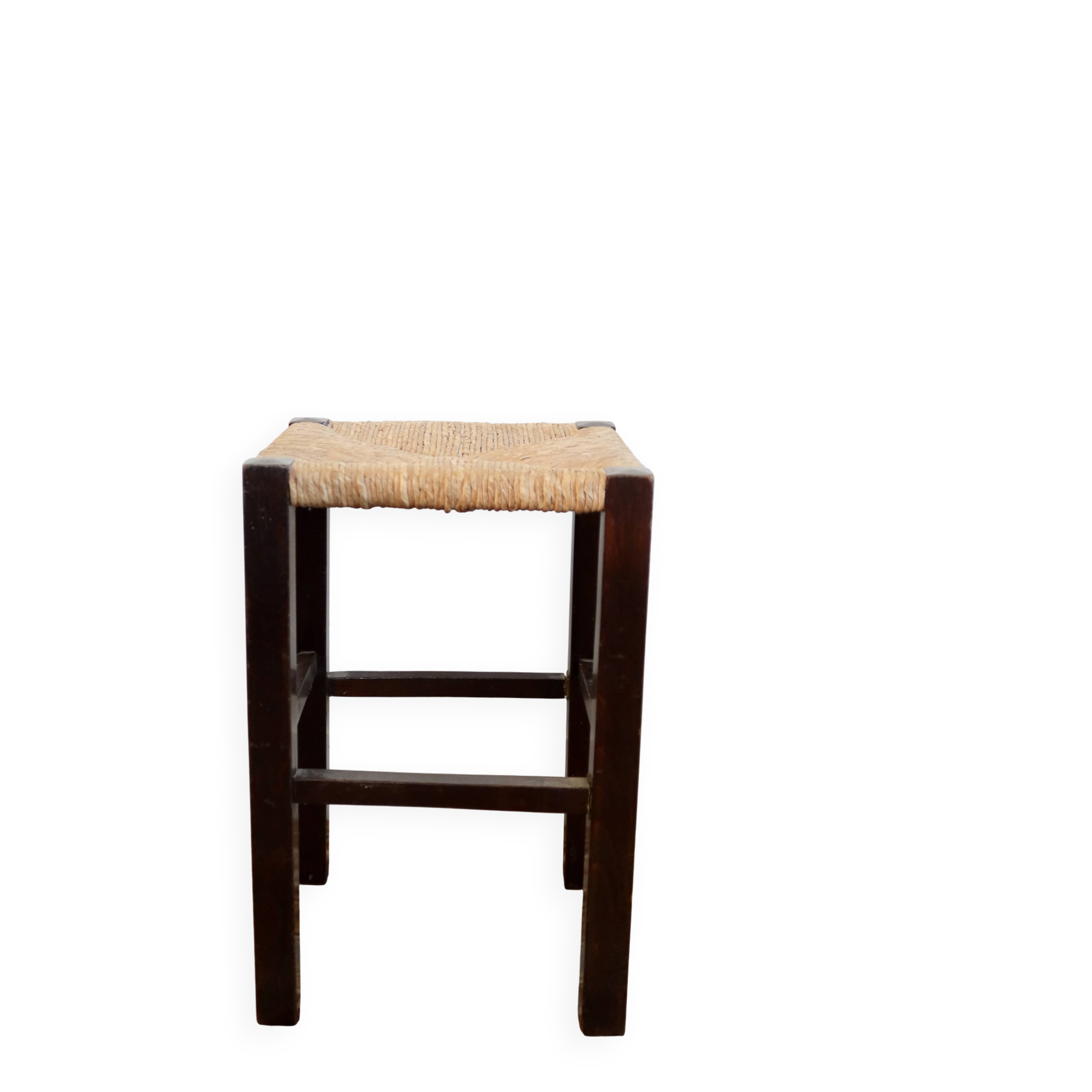 Vintage rustic stool in wood with a straw seat.