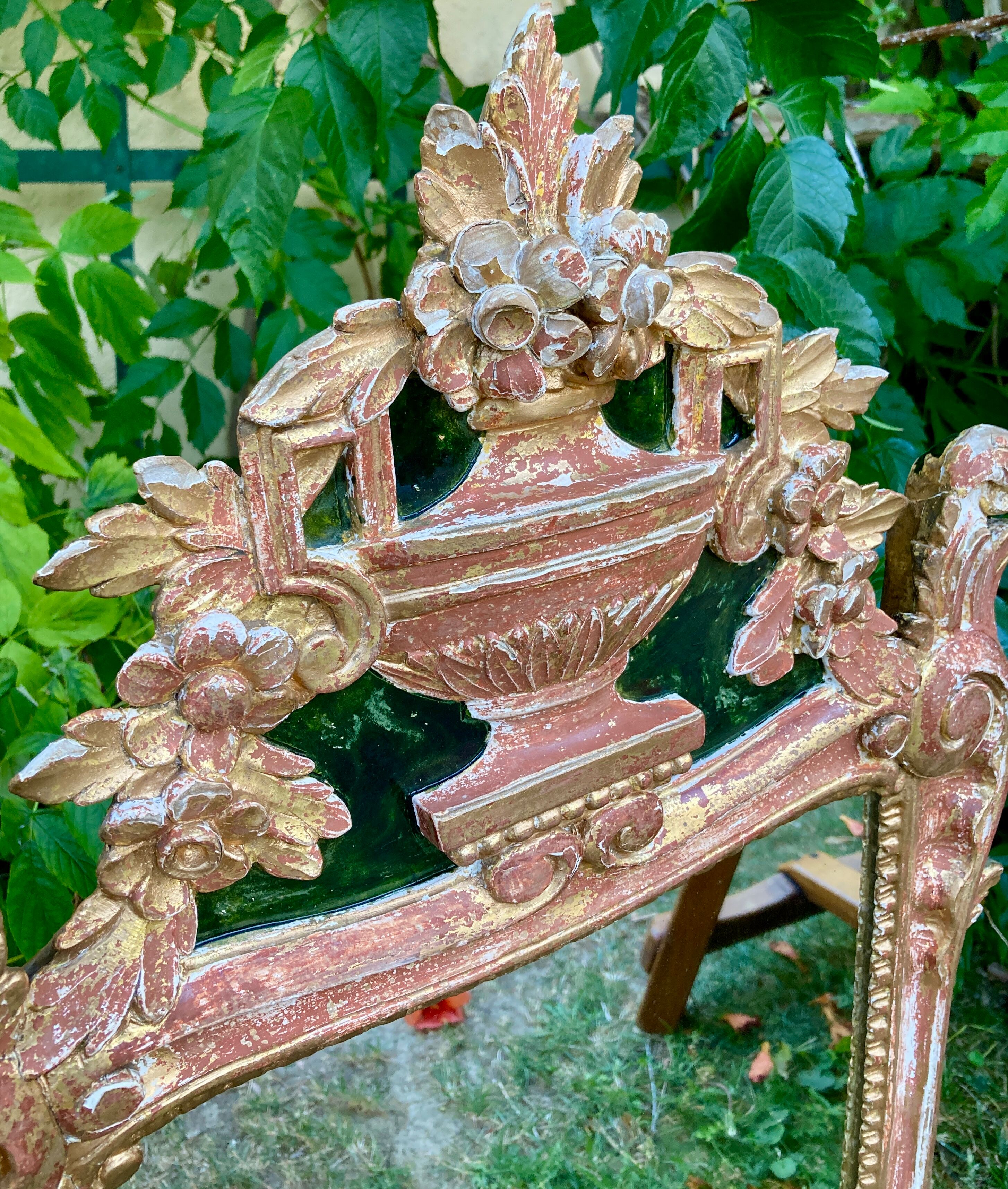 Mirror above a wooden and gilded stucco fireplace in the style of the 18th century.