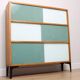 A vintage mid-century 3 tiered bookcase with glass sliding doors