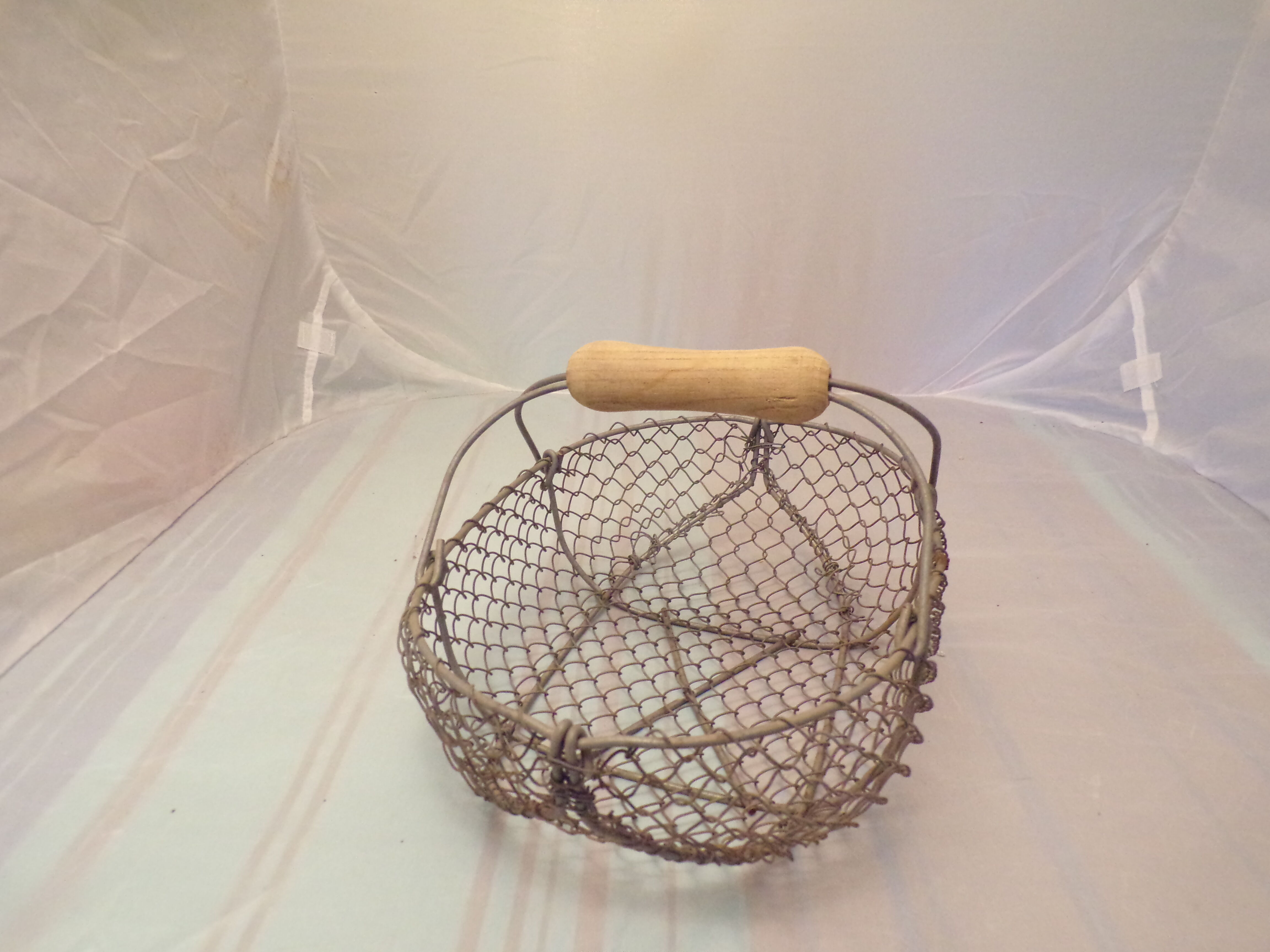 Basket has former apples in metal and wire mesh