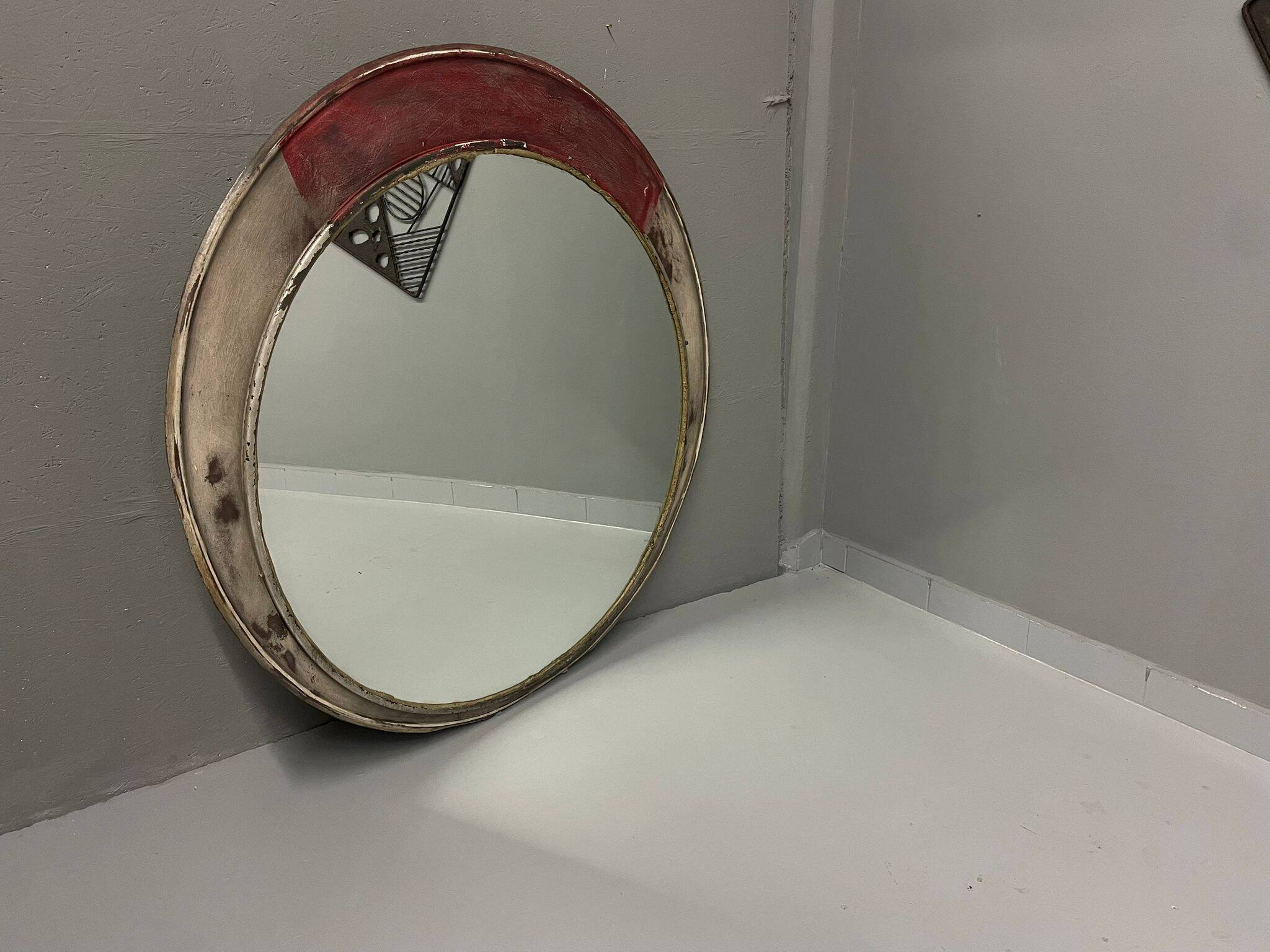 Vintage round mirror with an industrial metal frame in a painted finish.