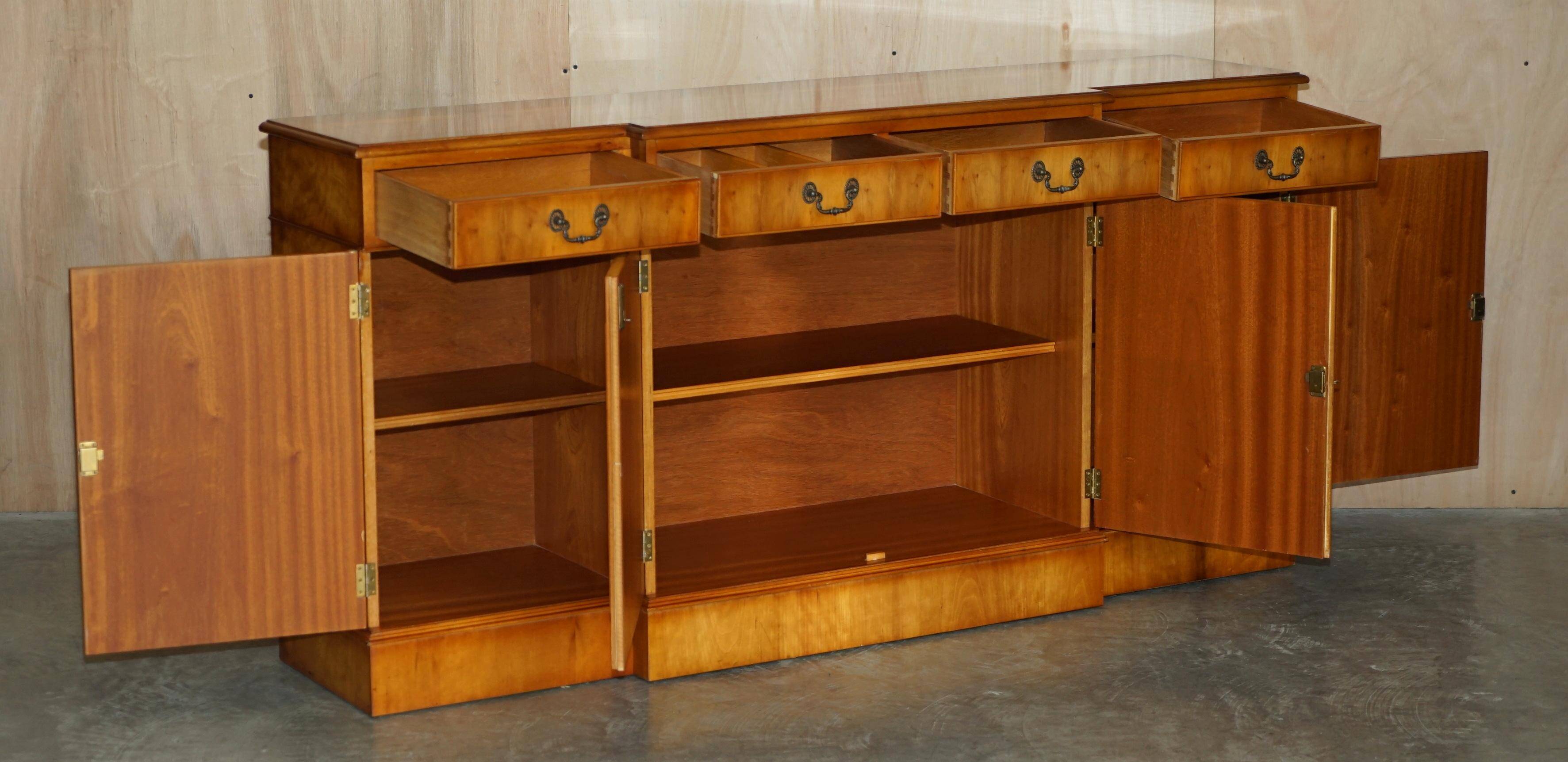 Vintage buffet made of mottled yew wood with three doors and four drawers.