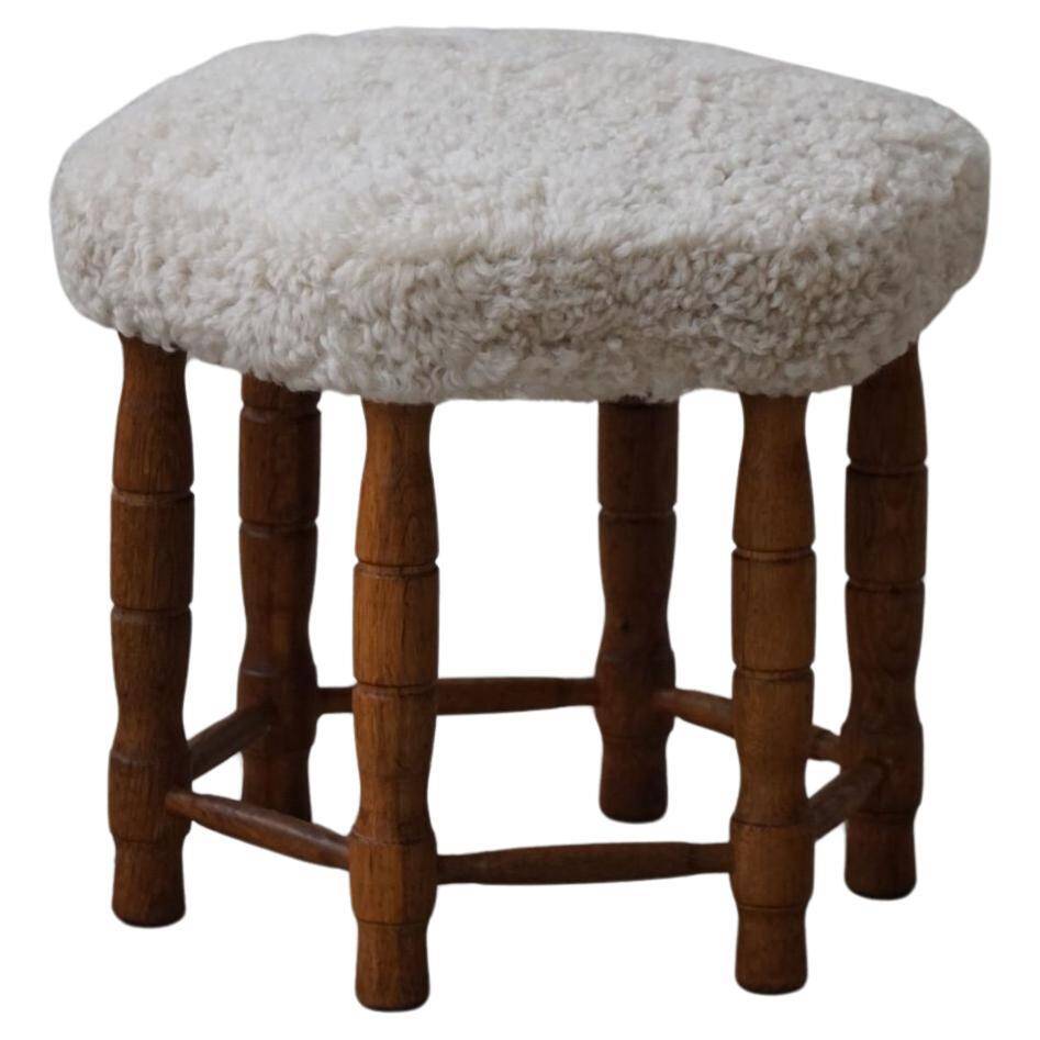 Modern Danish, a hexagonal oak stool, seat reupholstered in lambswool, 1950s.