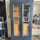Black painted wardrobe with two glass doors and an interior sideboard.