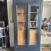 Black painted wardrobe with two glass doors and an interior sideboard.