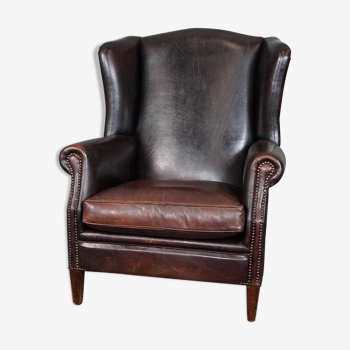 Dark patinated leather armchair