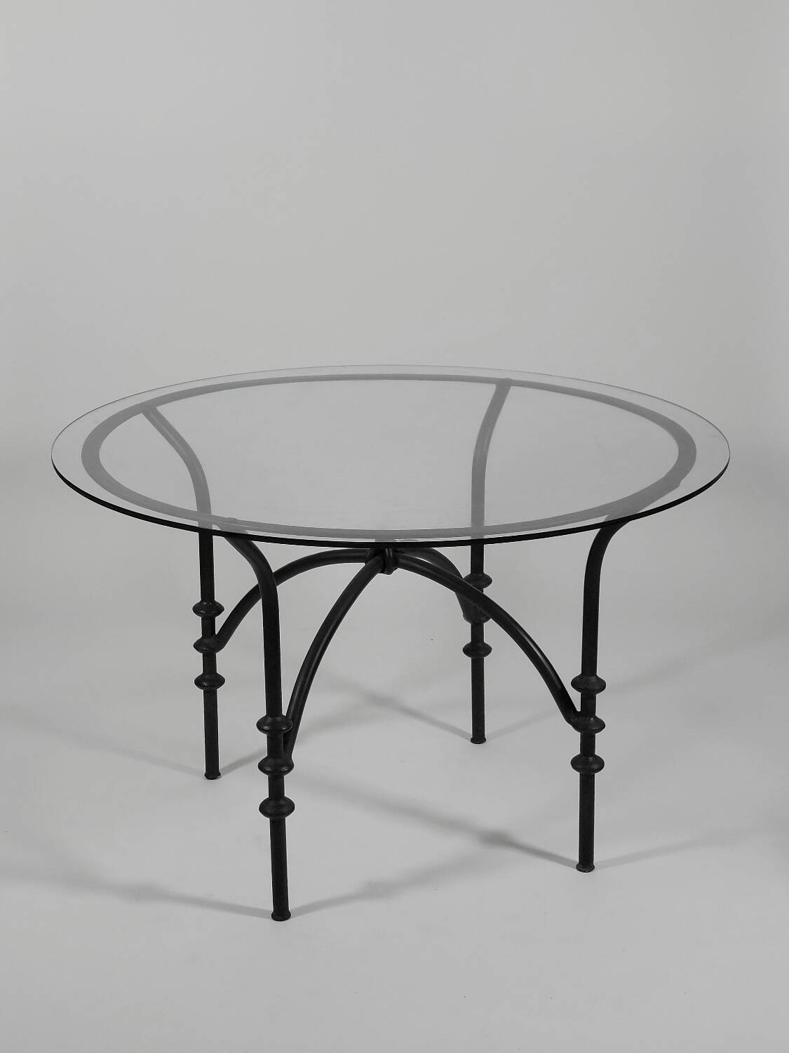 Table à manger vintage avec base tubulaire et plateau en verre avec un nœud.