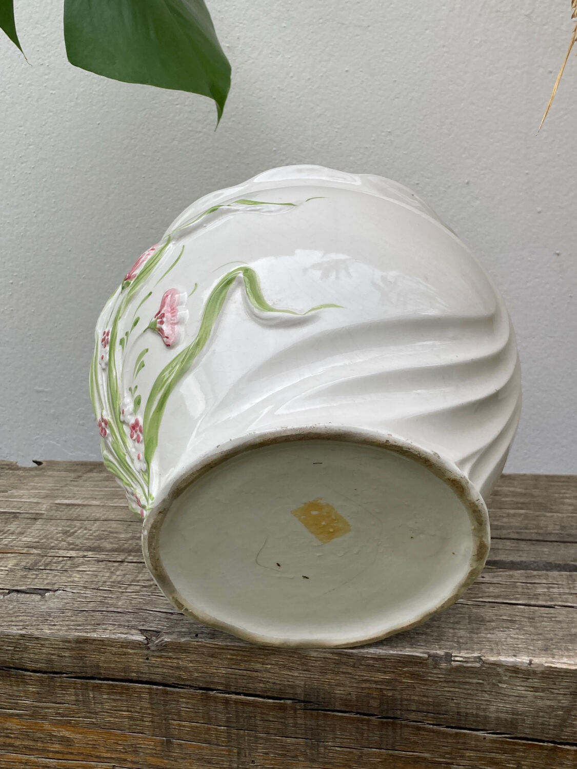 White ceramic pot cache of flower slip and old green foliage