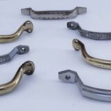 Seven art deco silver tone and brass handles
