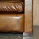 Three-seater Art Deco style leather sofa with feather cushions.