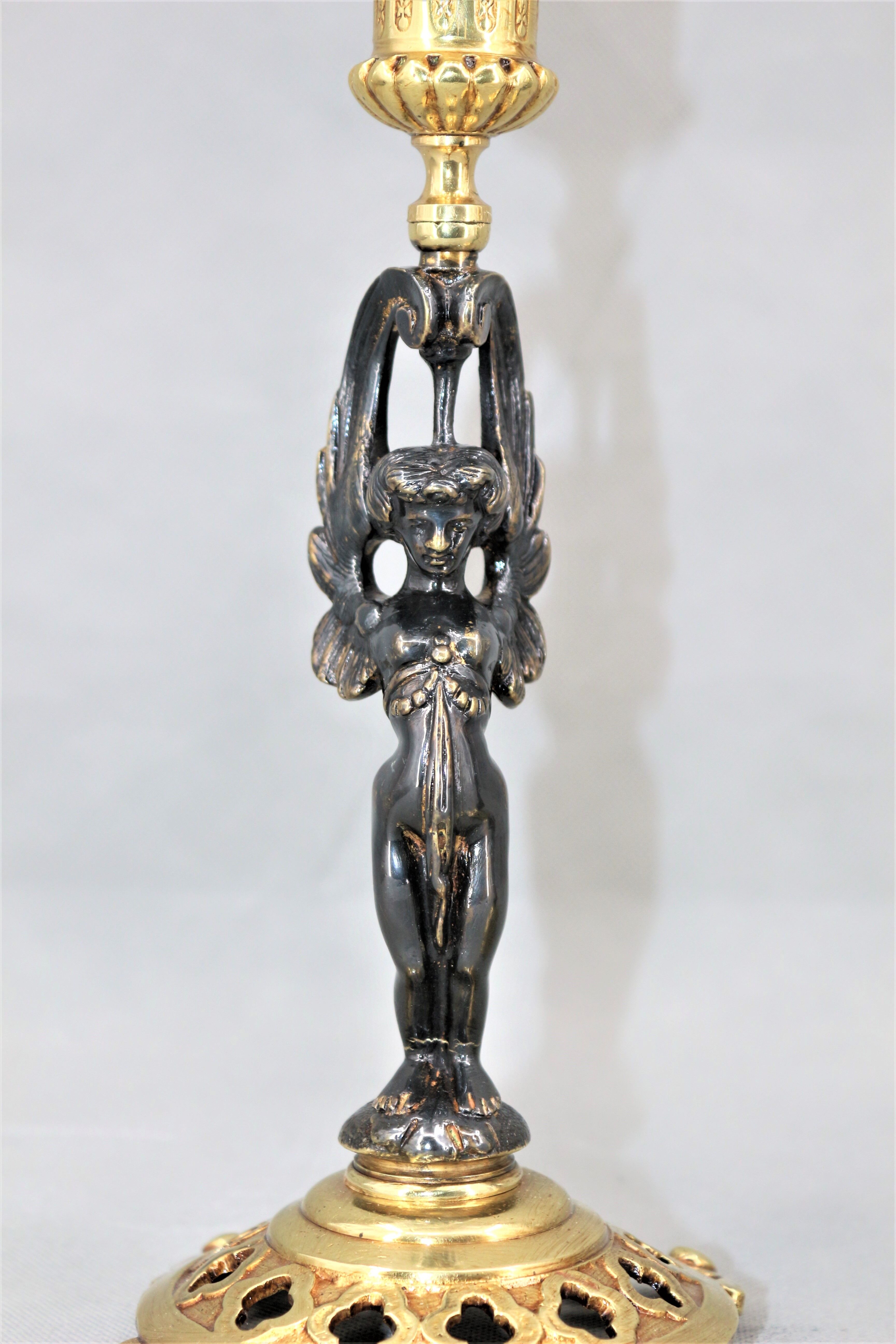 Pair of candle holders in gilded bronze and patinated with a candle