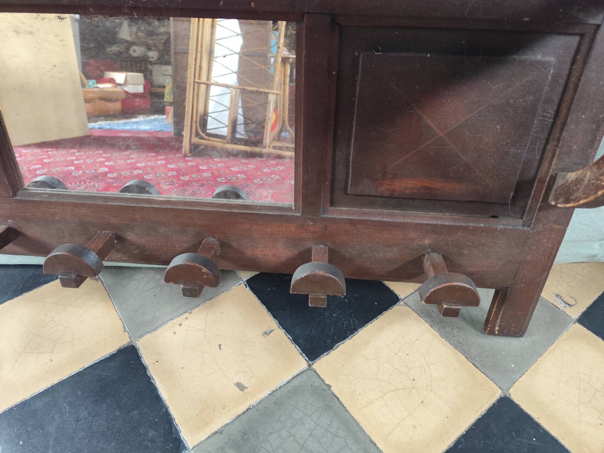 Wall-mounted coat rack with mirror and hat holder.