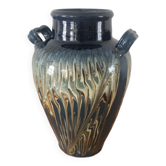 Vase in glazed ceramic decoration drips on blue background