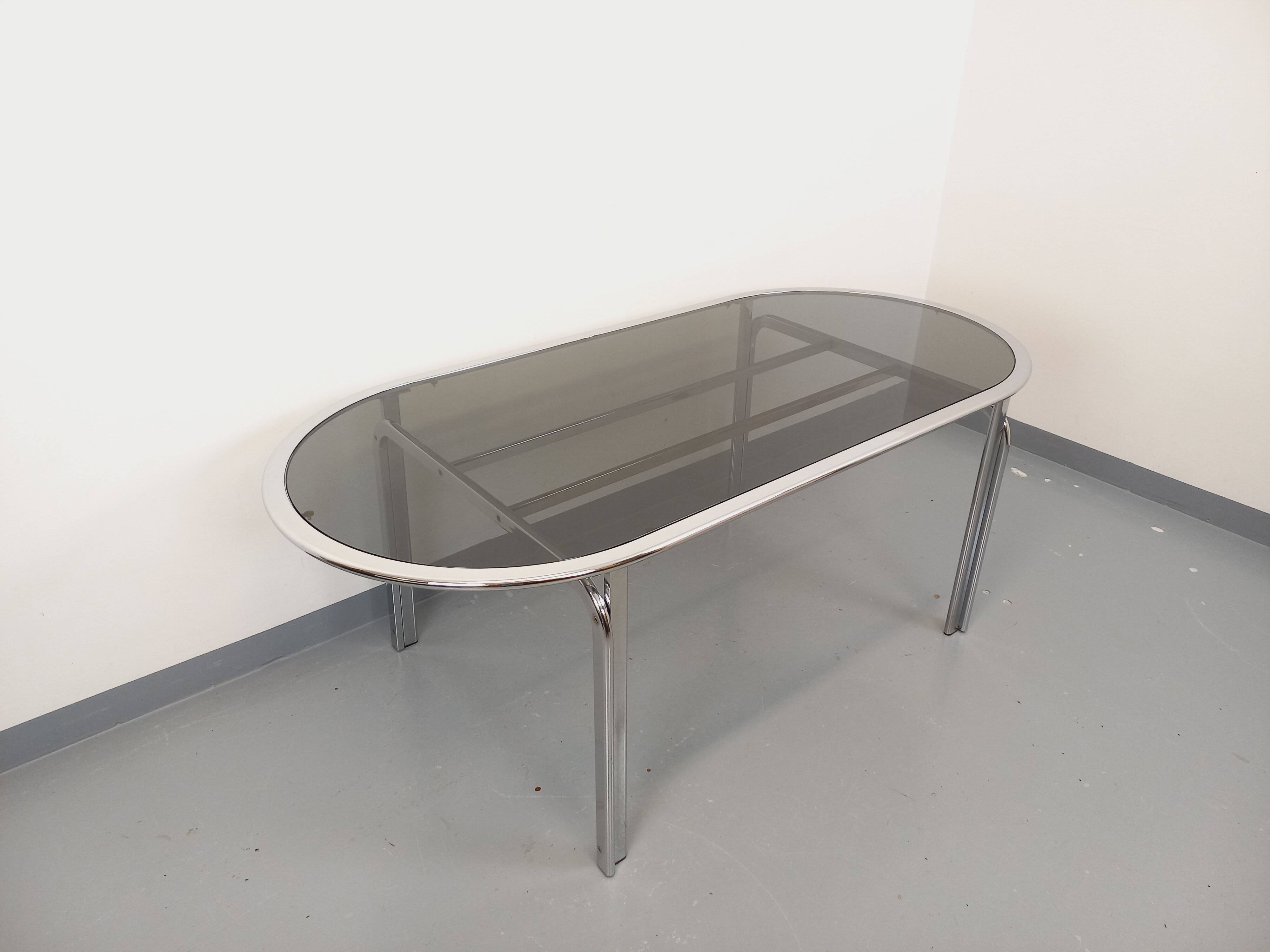 Vintage oval dining table in smoked glass and chrome metal, Space Age style.