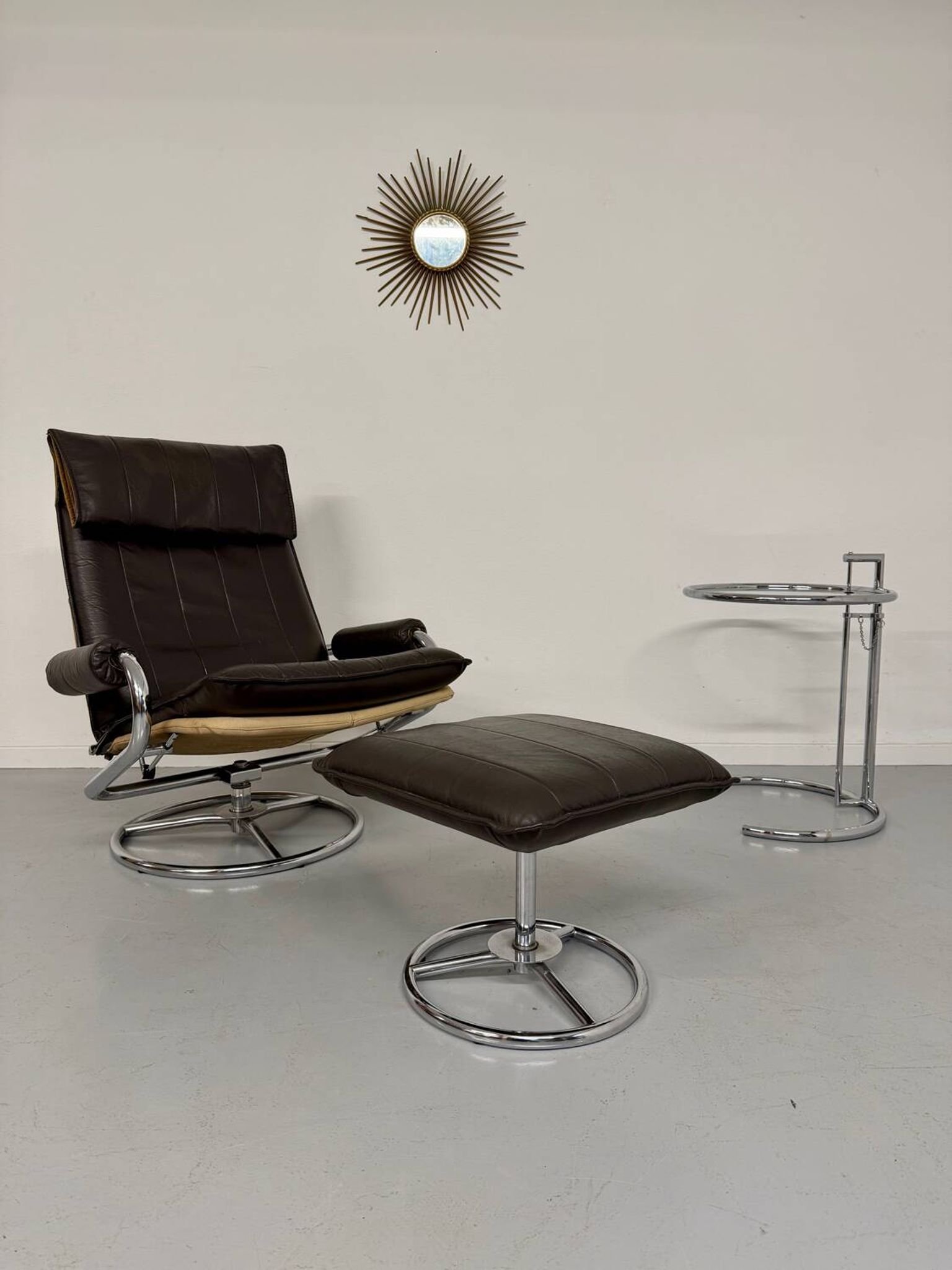 Vintage leather reclining armchair and its 1970s designer ottoman.