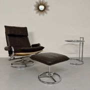Vintage leather reclining armchair and its 1970s designer ottoman.