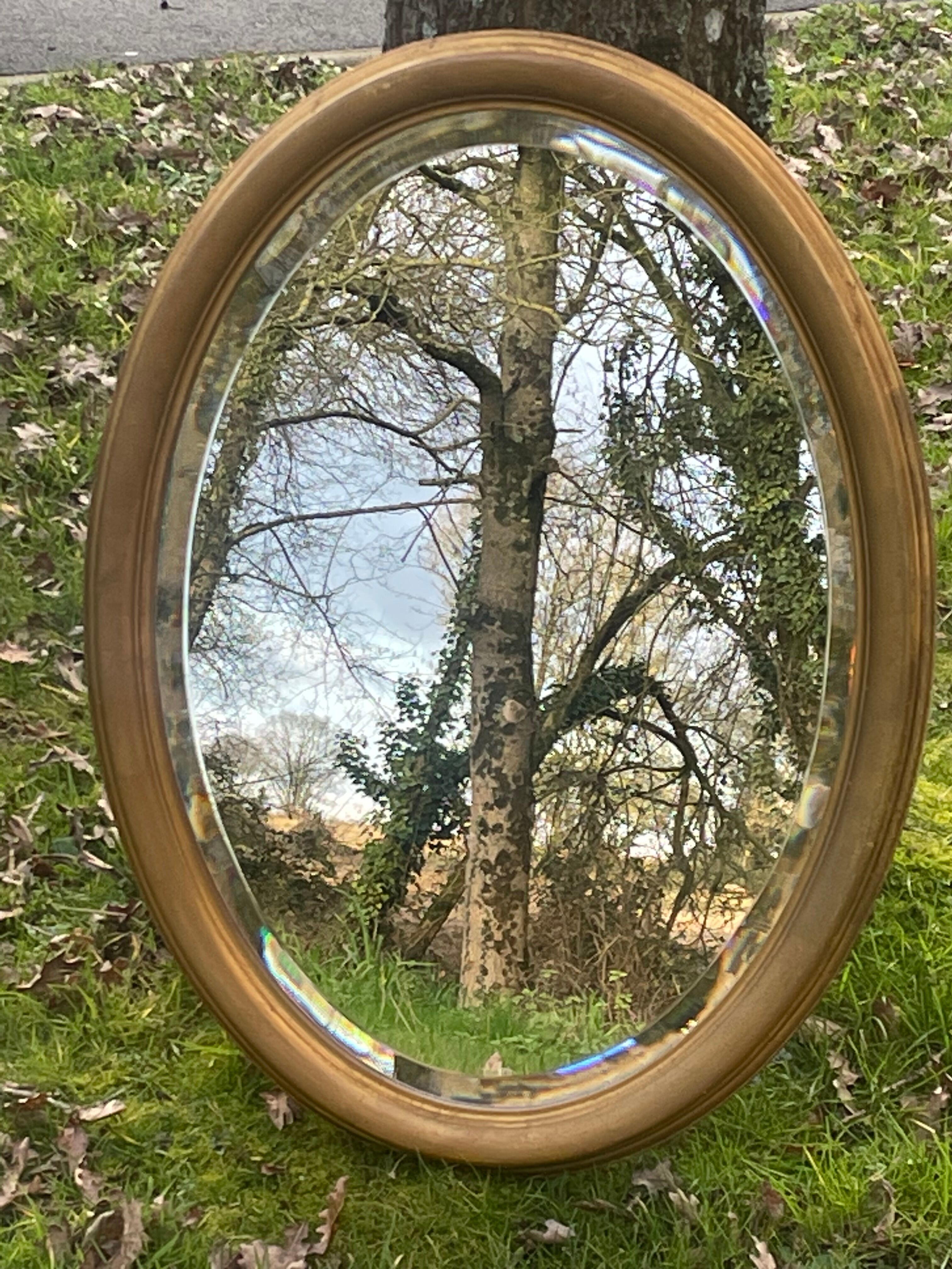 Bevelled golden oval mirror, 79 x 59 cm