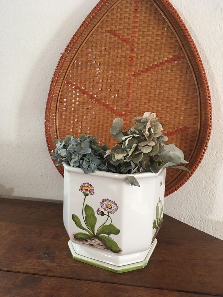 Cover - white ceramic pot decorated with stylized flowers.