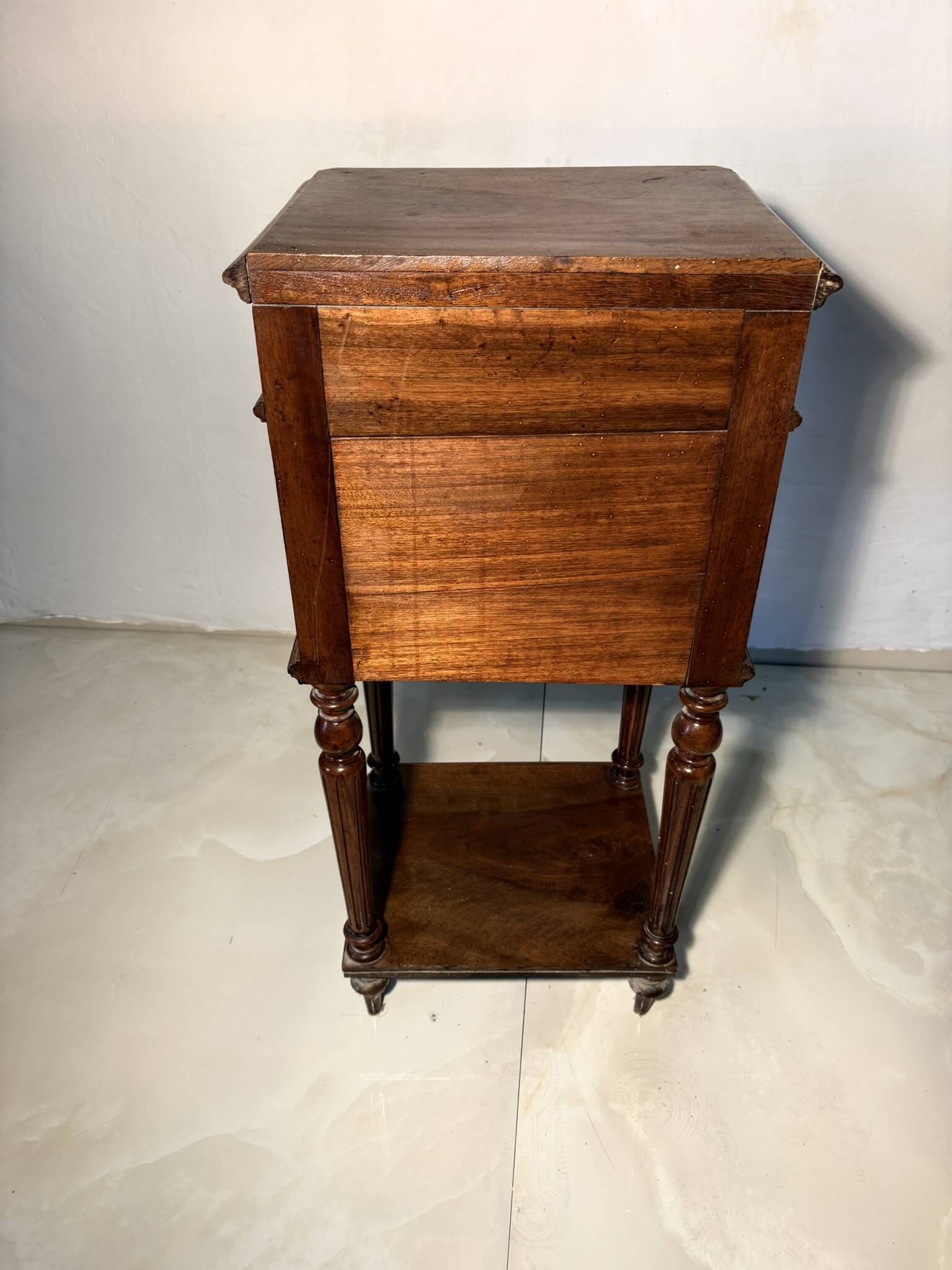 Antique wooden bedside table with turned legs.