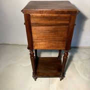 Antique wooden bedside table with turned legs.