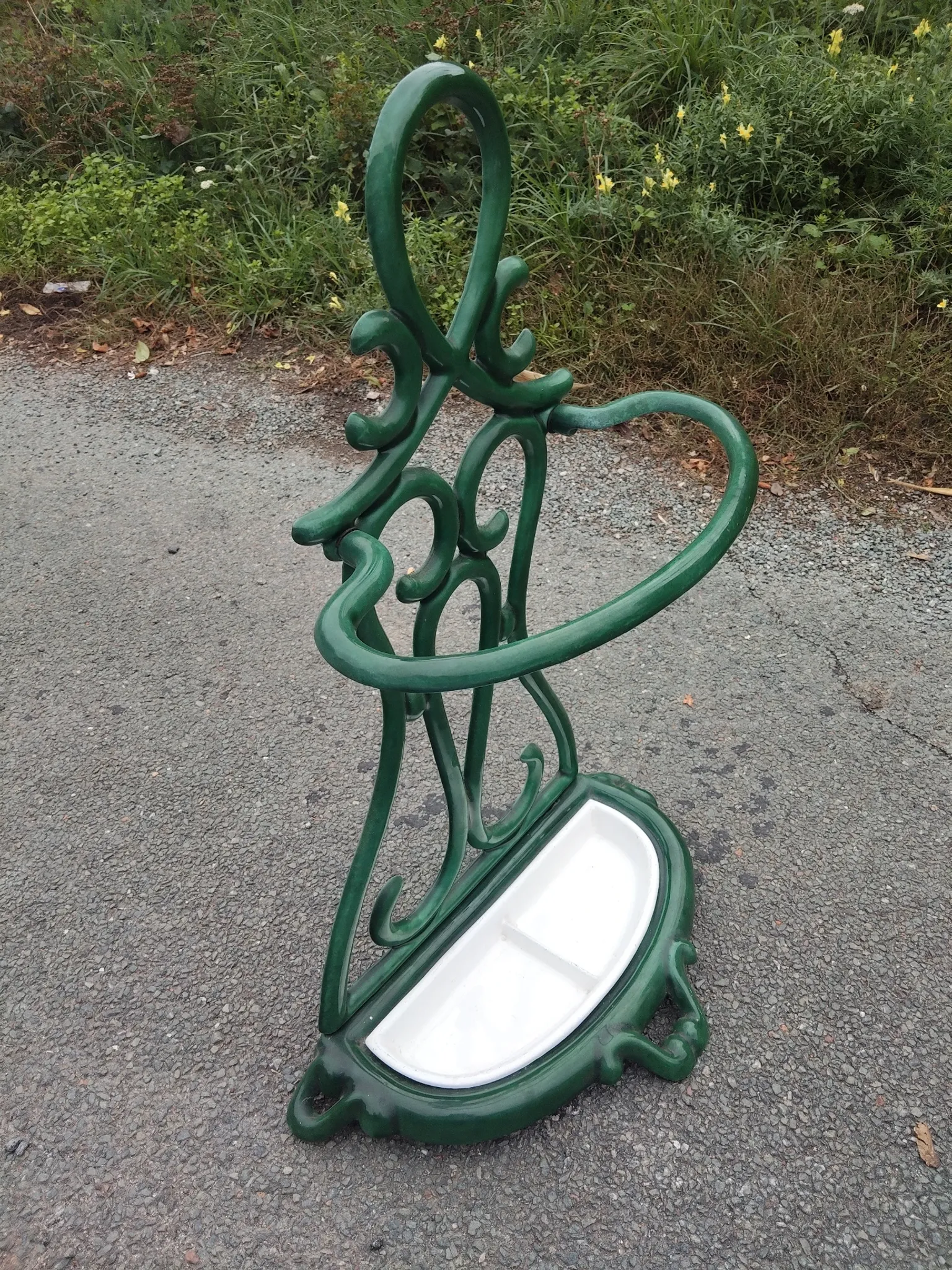 Bottle green enamelled cast iron umbrella stand with a swirl design.