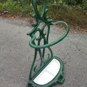Bottle green enamelled cast iron umbrella stand with a swirl design.