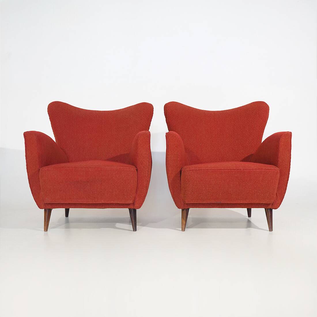 Pair of red armchairs with cone-shaped feet, 1950s