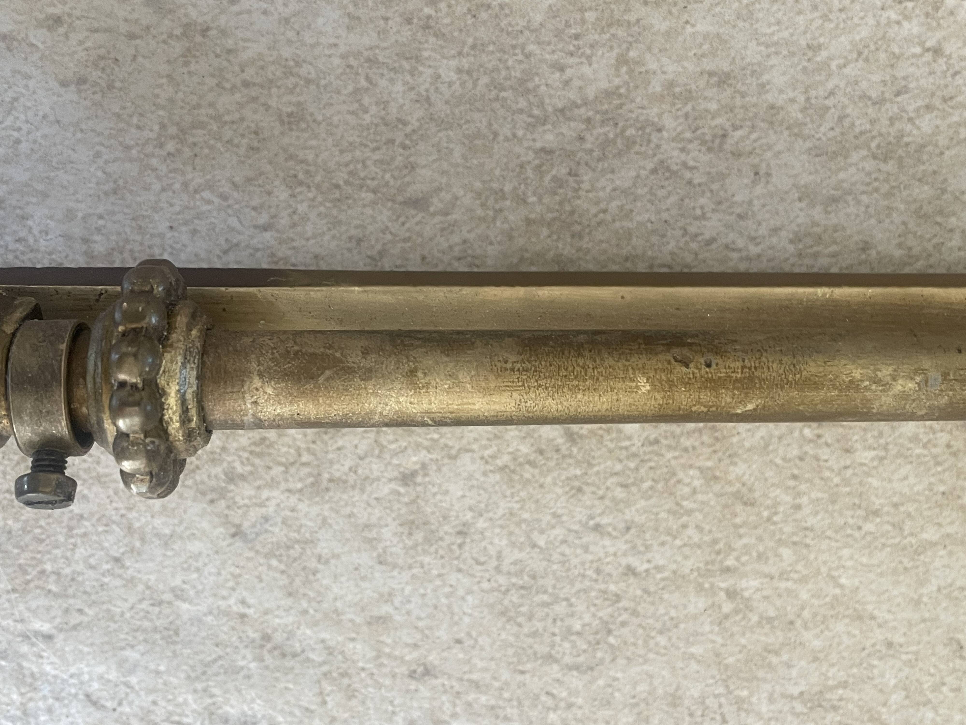 Adjustable wall light in brass and gold metal.