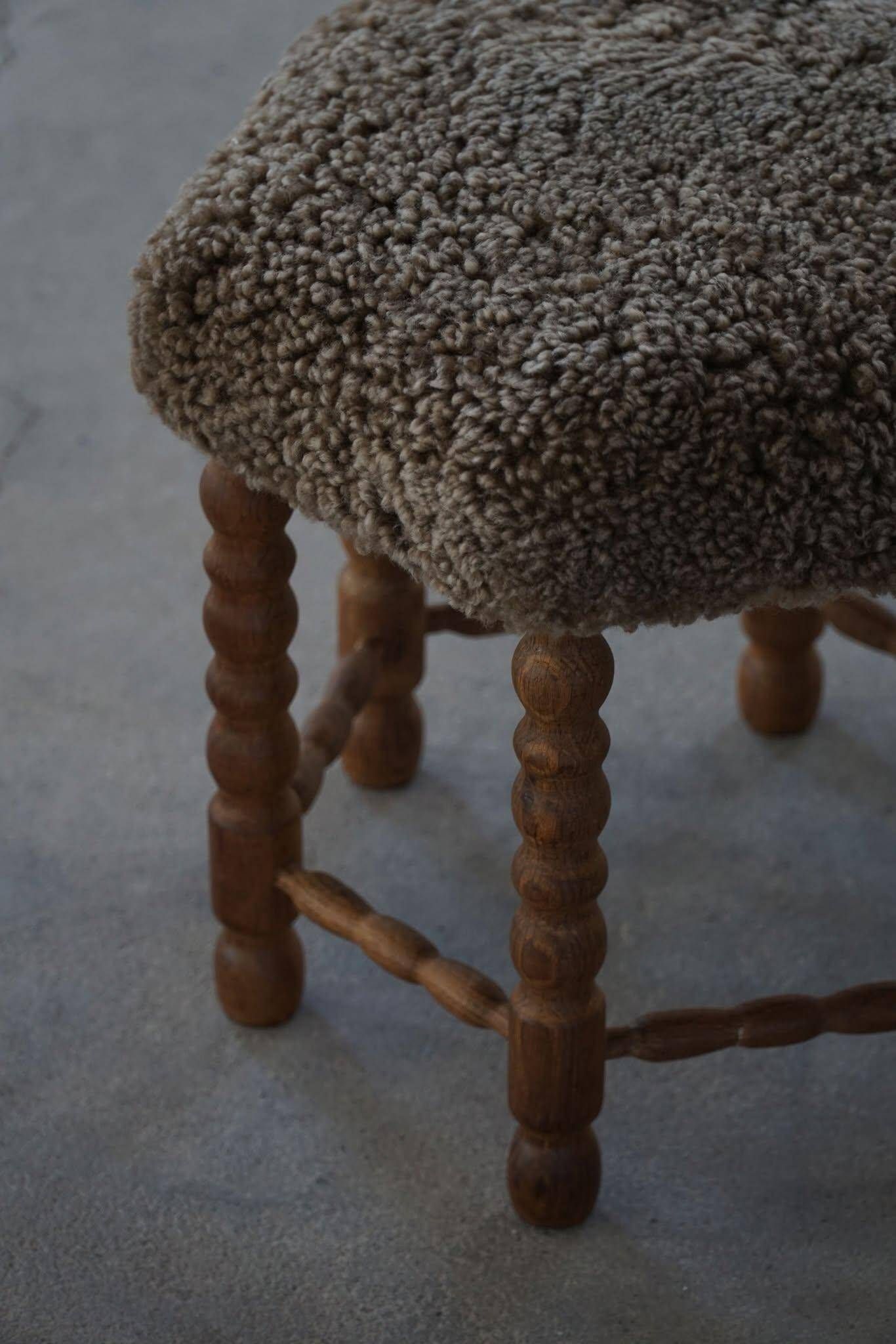 Un tabouret hexagonal en chêne, siège réhabilité en laine d'agneau, design danois des années 1950