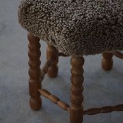 Un tabouret hexagonal en chêne, siège réhabilité en laine d'agneau, design danois des années 1950