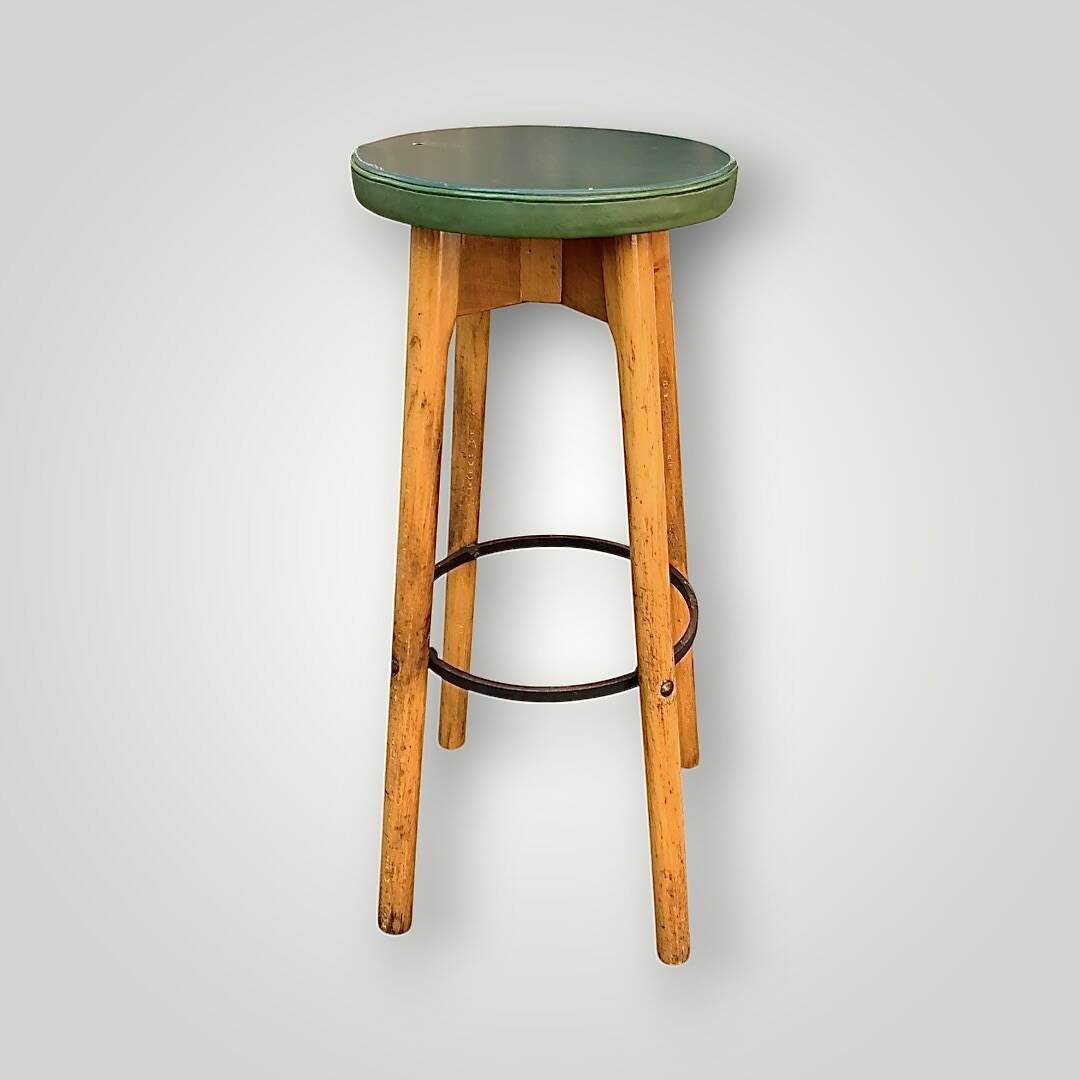 Old solid wood bar stool, metal footrest, green leatherette seat