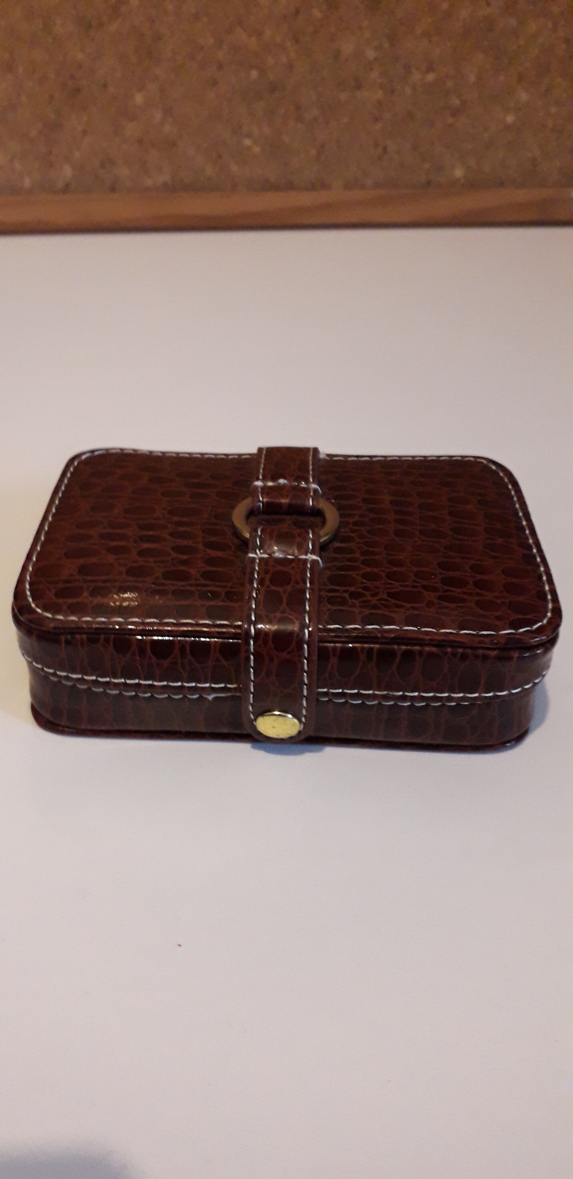 Small travel alarm clock in its case with jewelry compartments