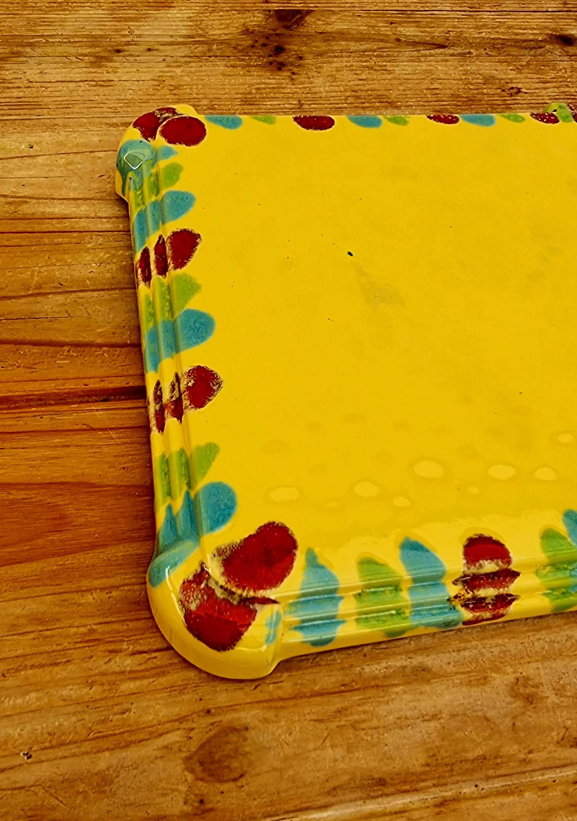 Yellow ceramic trivet and bottle coaster with vintage painted decoration.