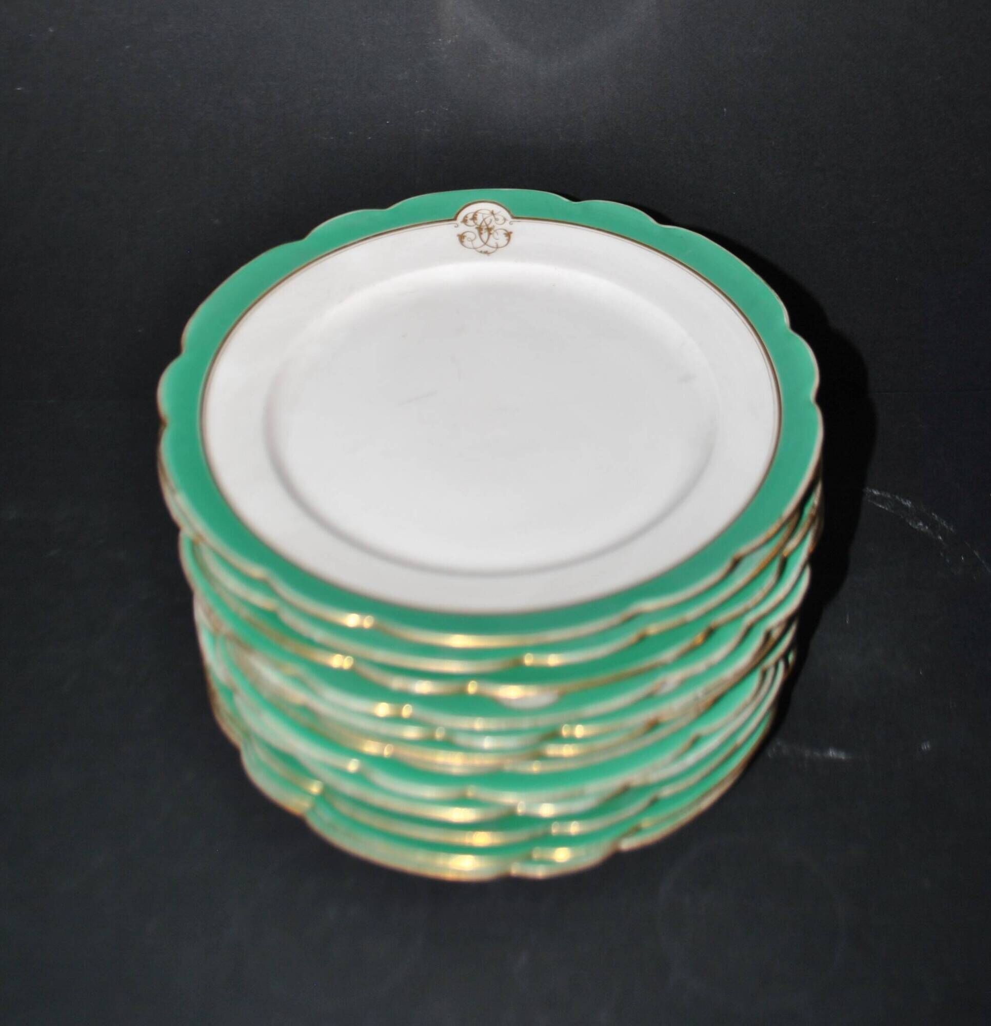Paris porcelain set of 12 flat plates with green border and gold monogram JC.