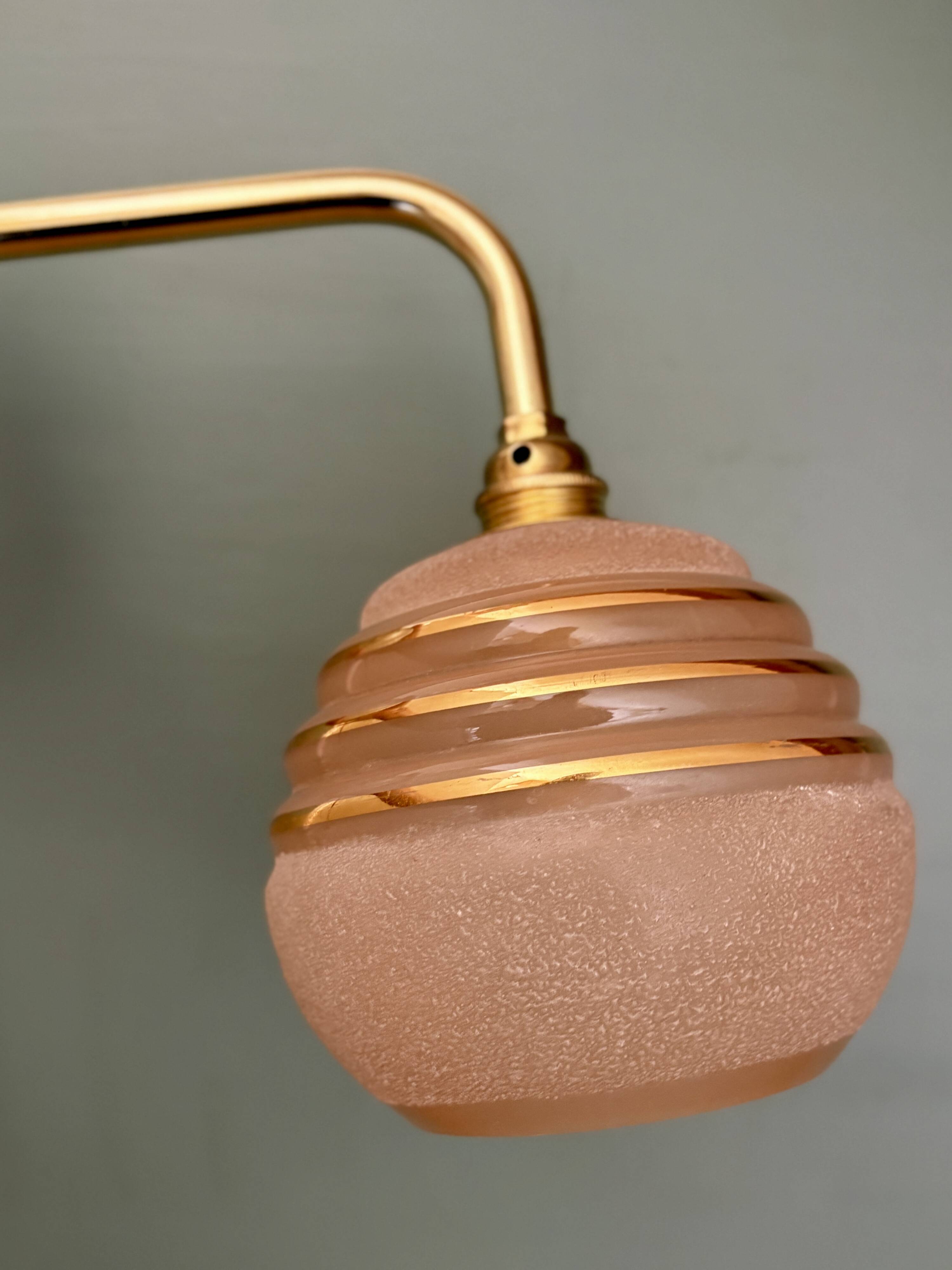 Vintage pink and gold frosted glass globe wall light.