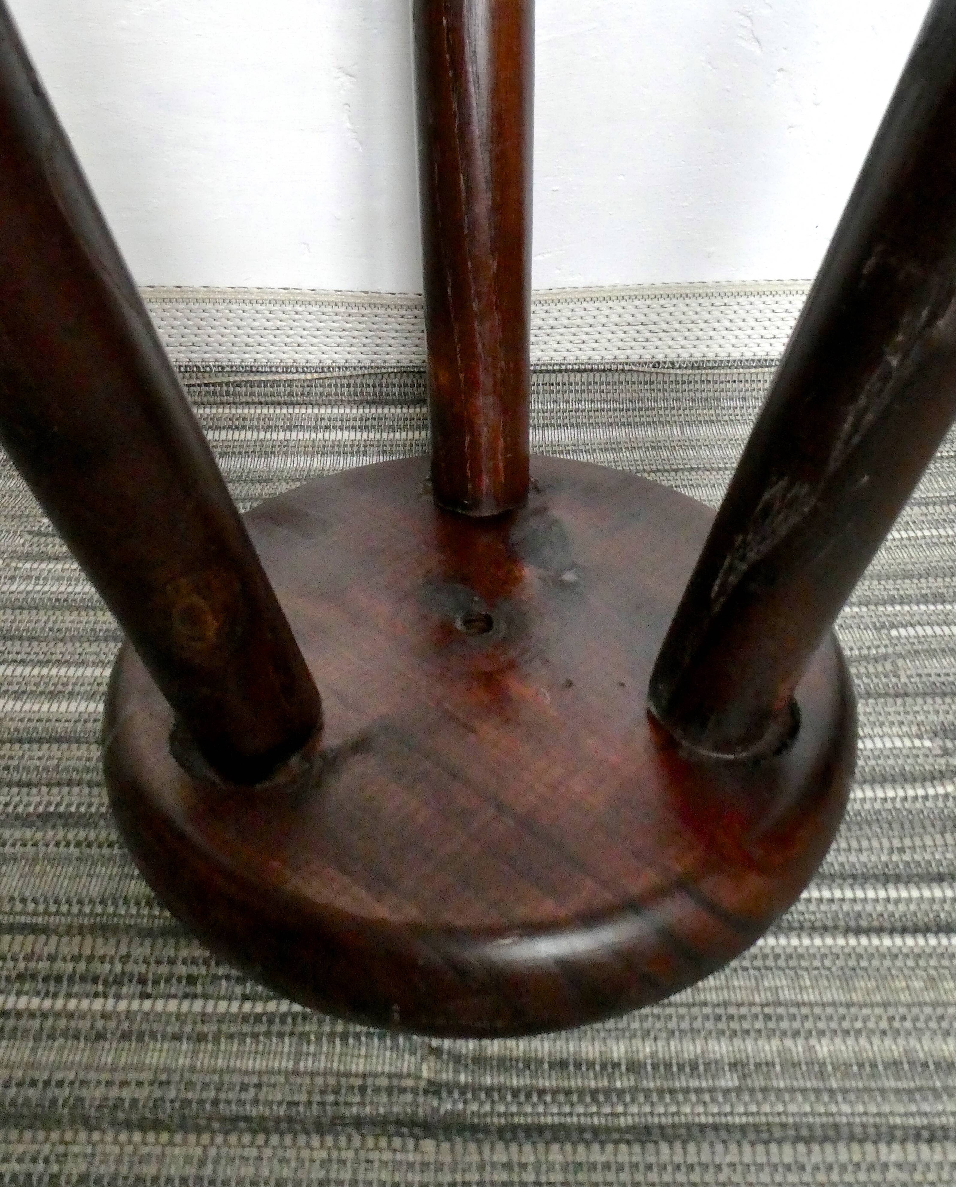 Dark wooden tripod stool