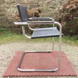 Design armchair with chrome metal tubular base and seat in black Skaï