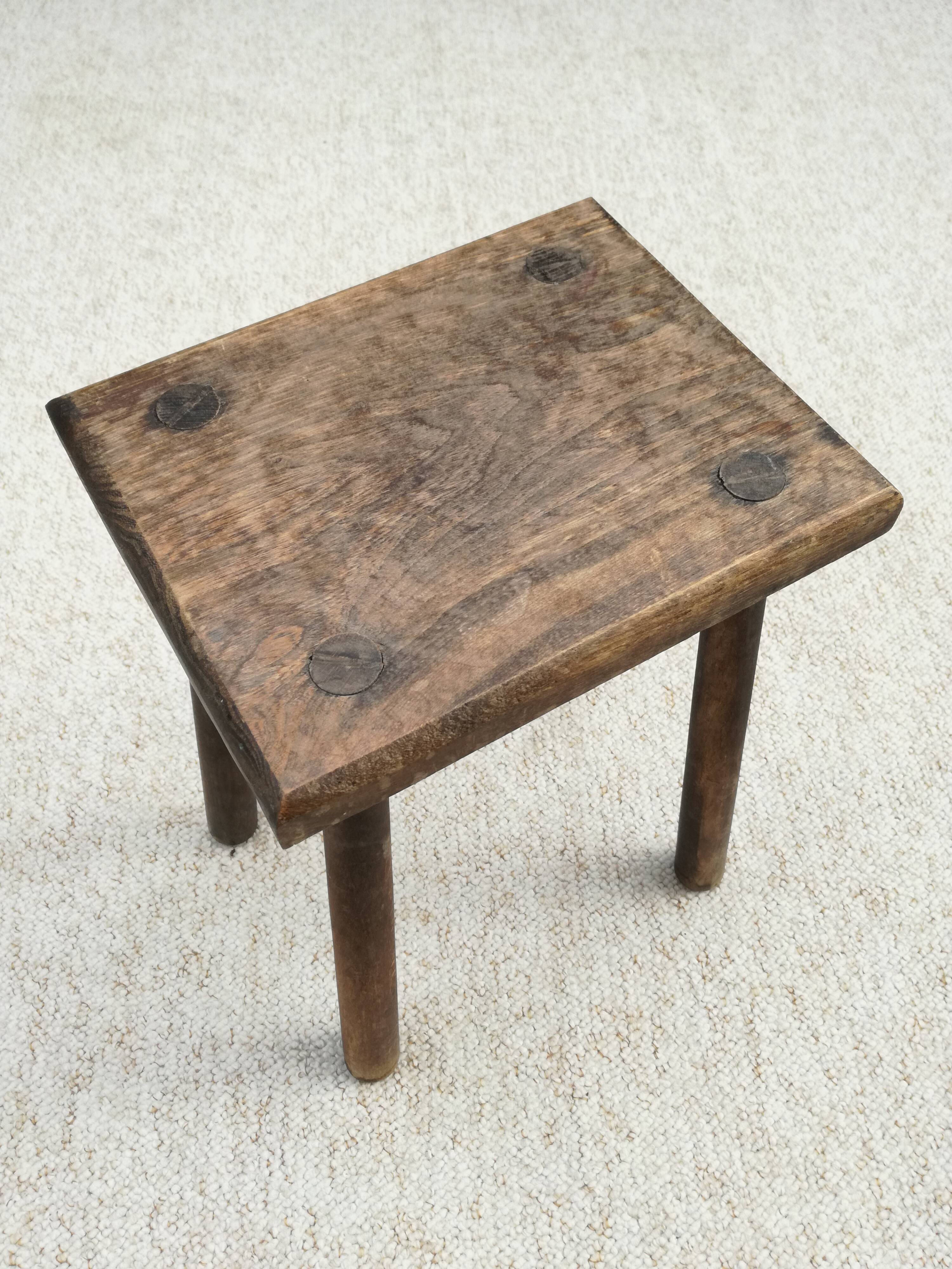 Old wooden stool with log feet