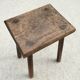 Old wooden stool with log feet