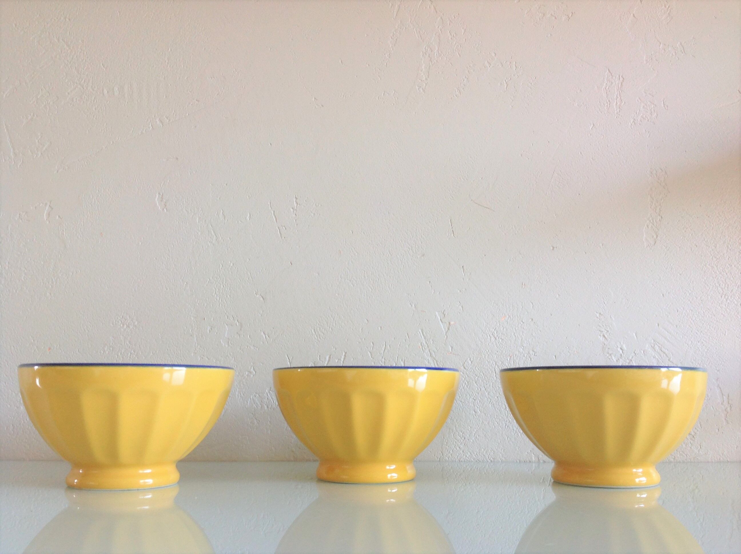 Suite of three yellow ribbed bowls with blue / vintage 70s border